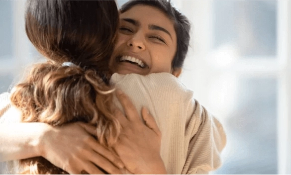 Duas mulheres abraçadas sorrindo de felicidade por realizar um sonho